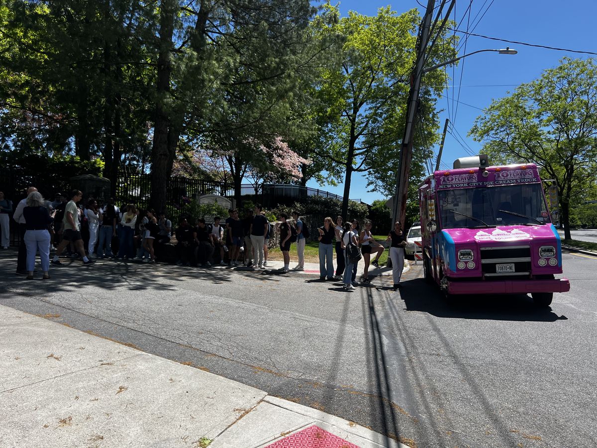 Line of guests waiting outside a school for the ice cream truck
