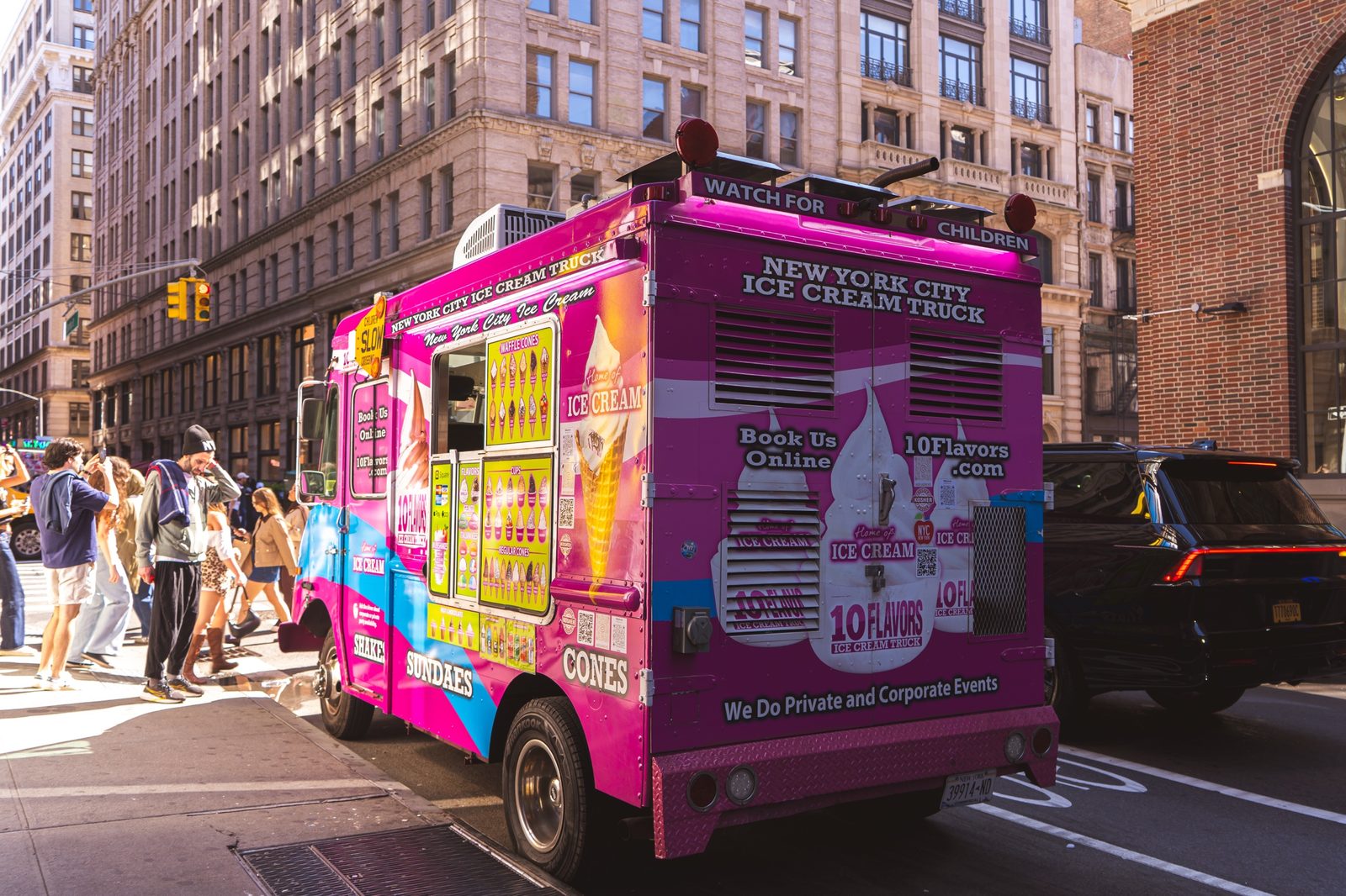 Rear view of the 10 Flavors ice cream truck with a Watch for Children sign on a NYC street
